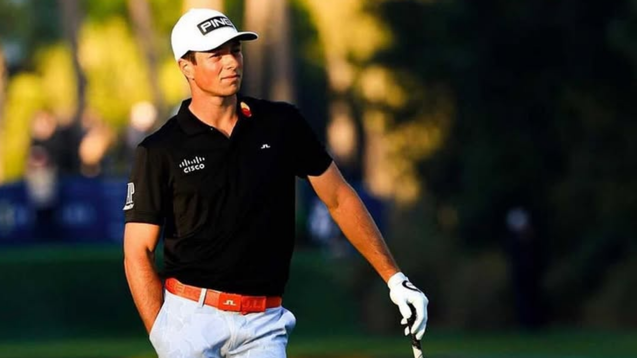Viktor Hovland observando o horizonte em meio ao campo de golfe.