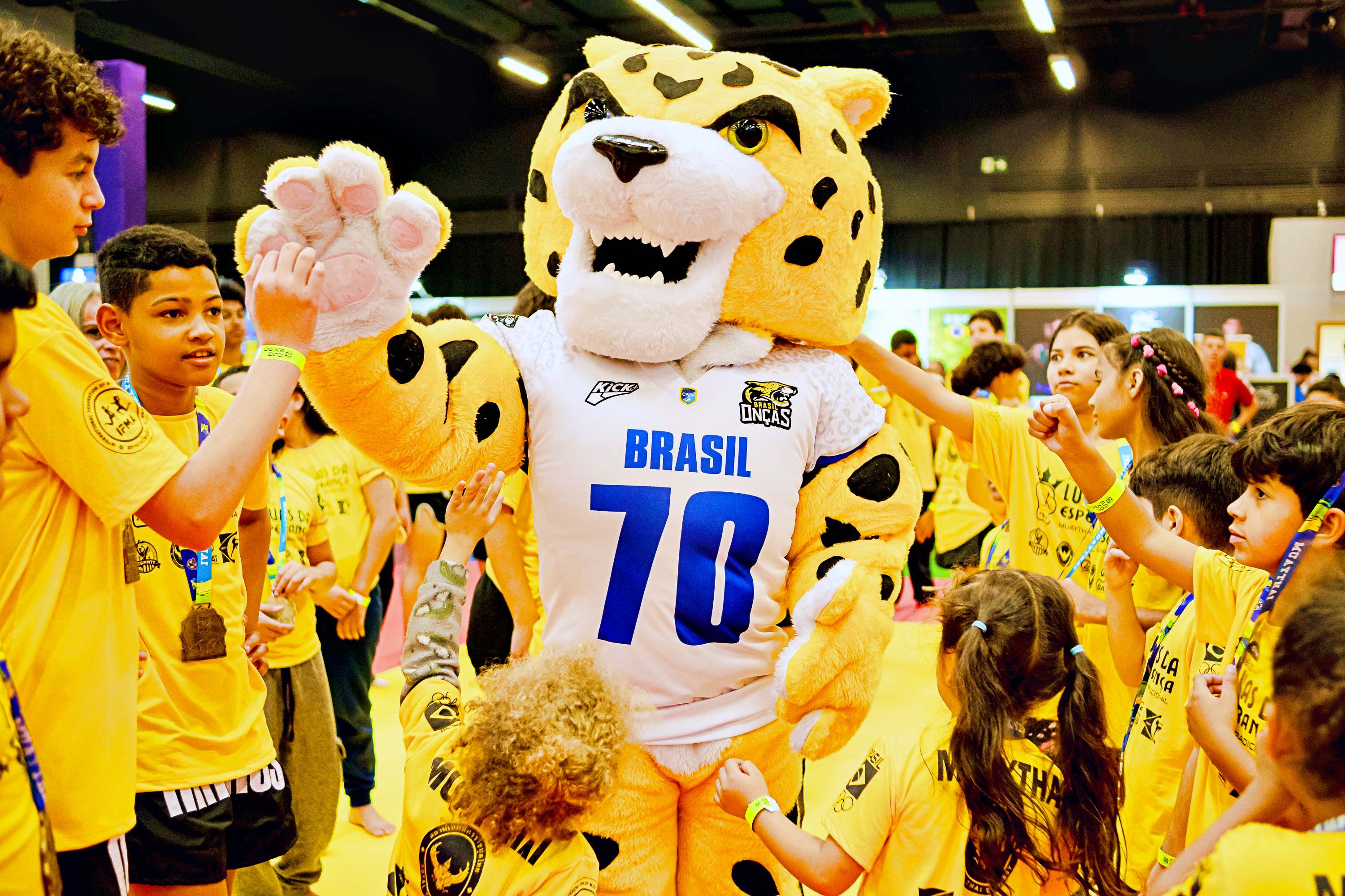 Mascote da Confederação Brasileira de Futebol Americano é cercado por crianças na COB Expo 2025